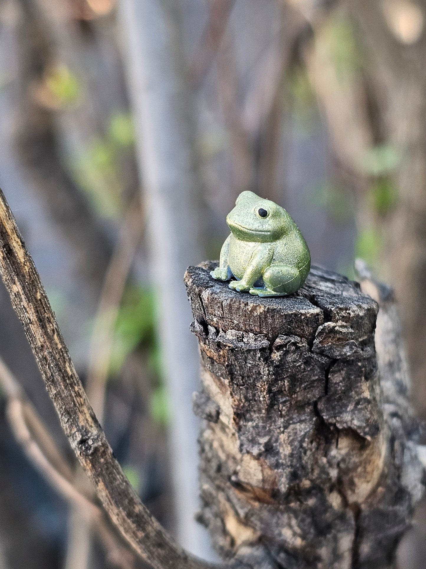 Tiny hand painted frog earring sitting on tree branch – Buck the Frog jewelry by Ghost Cactus Co